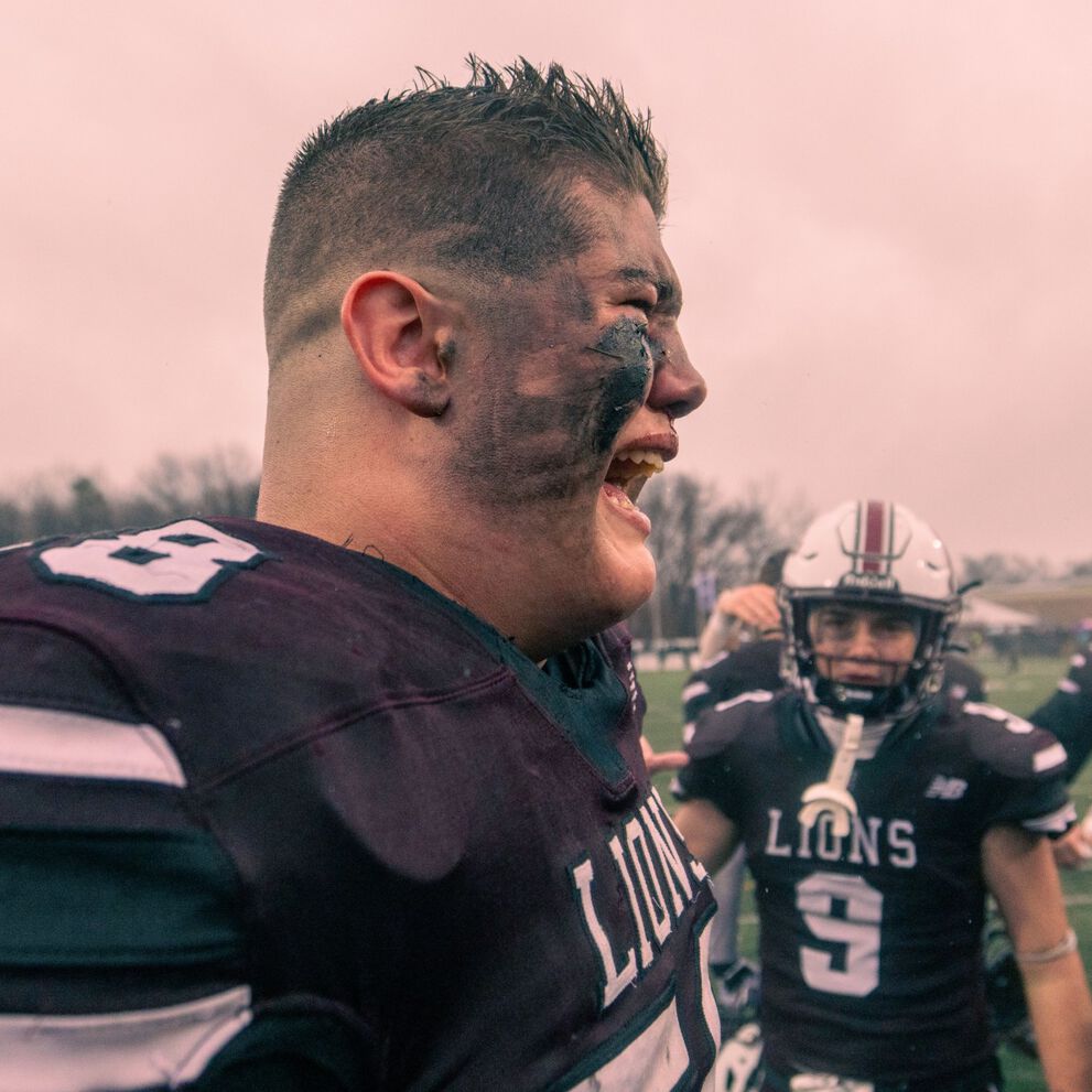 Young man yelling out on the football field.