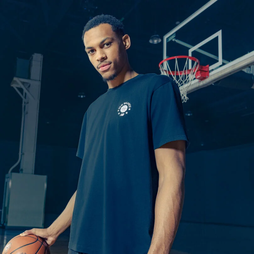 Darius wearing a navy tshirt standing under the bucket.