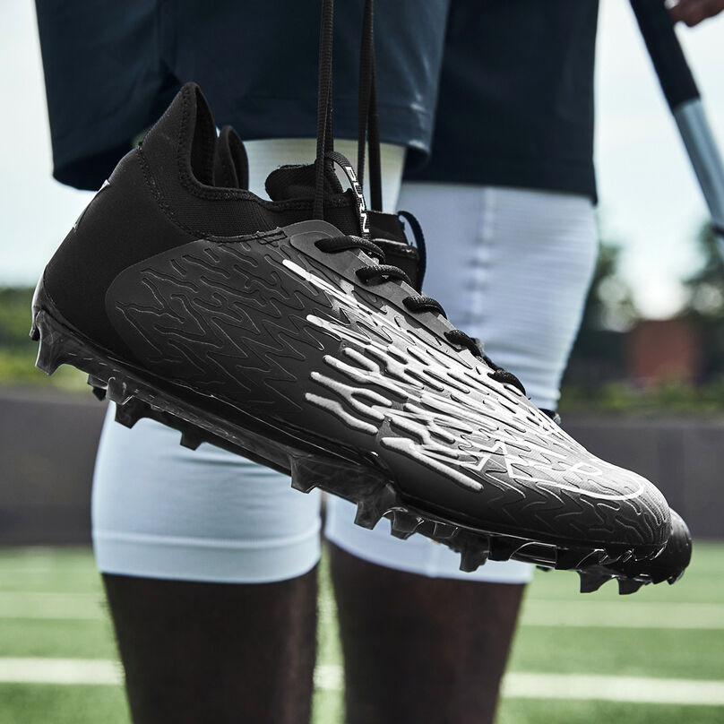 Black cleat hanging from the laces focusing on the heel.