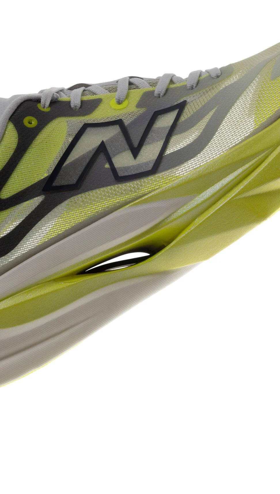 Gros plan d&rsquo;une chaussure de course New Balance pr&eacute;sentant une empeigne en filet translucide gris et vert lime, un logo &laquo;&nbsp;N&nbsp;&raquo; surdimensionn&eacute; au contour noir et une semelle intercalaire sculpt&eacute;e vert lime offrant un amorti g&eacute;n&eacute;reux.&nbsp;