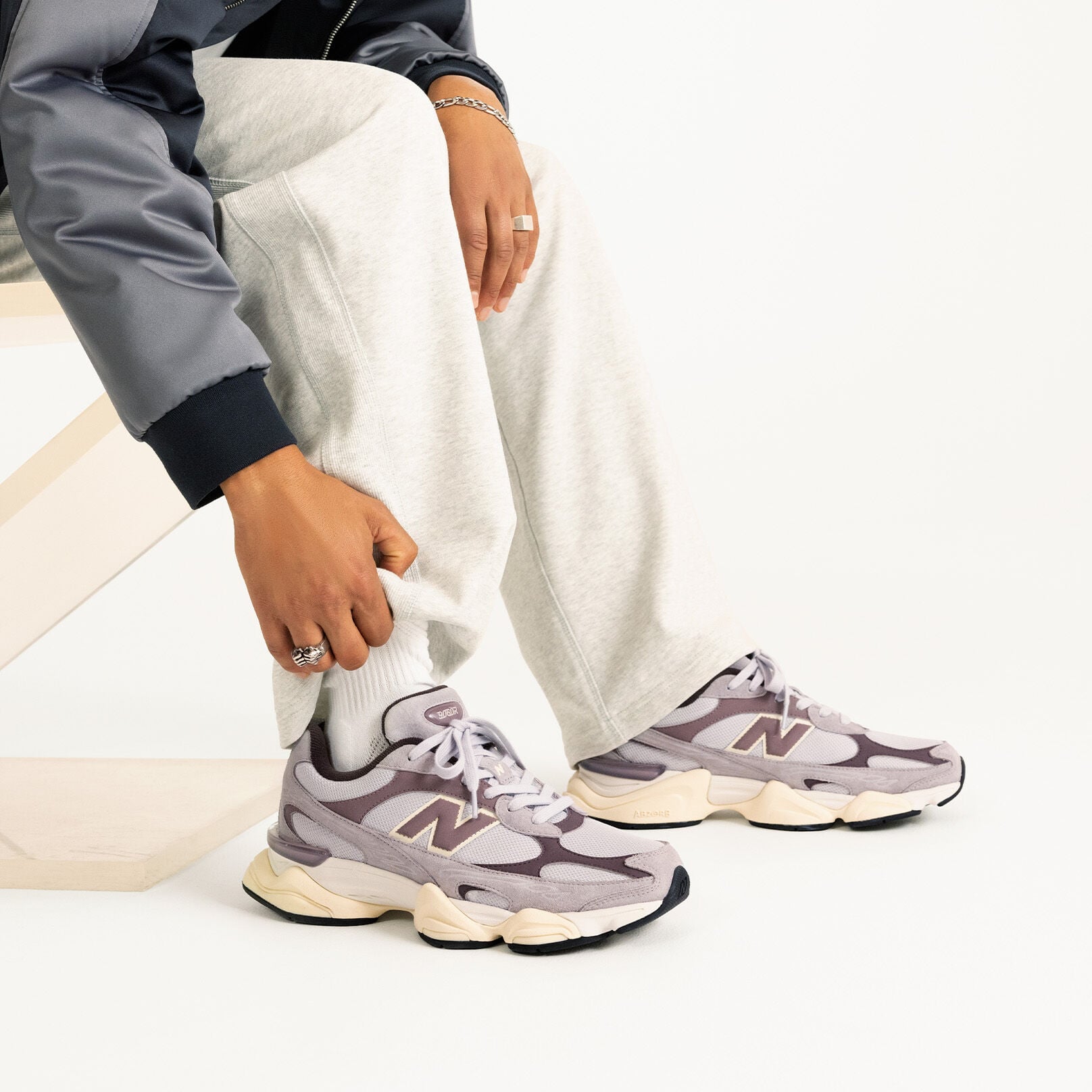 Personne &agrave; genoux portant une paire de baskets Crimson Fog 9060