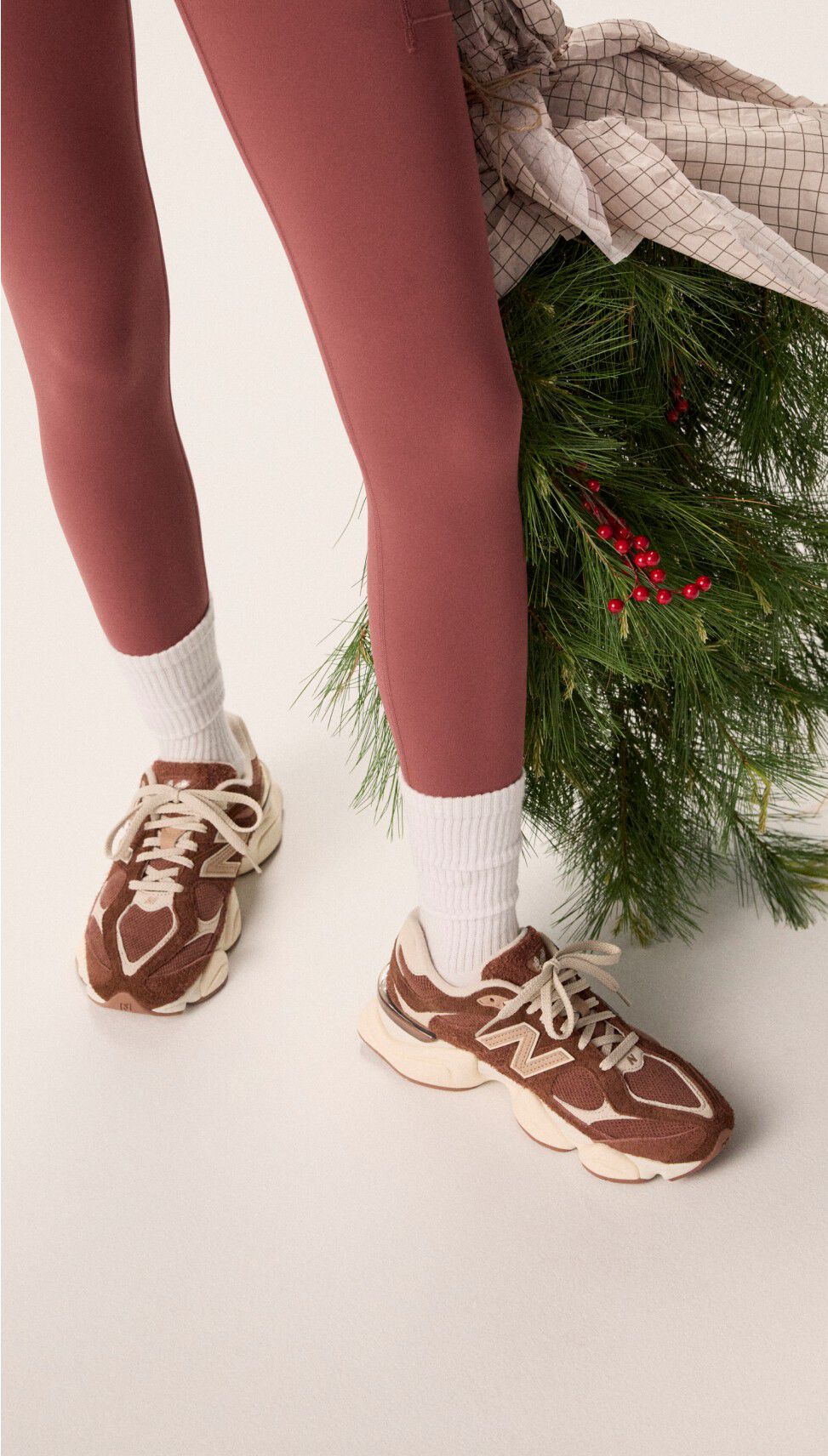 Femme portant des collants bordeaux tenant un sac de guirlandes.