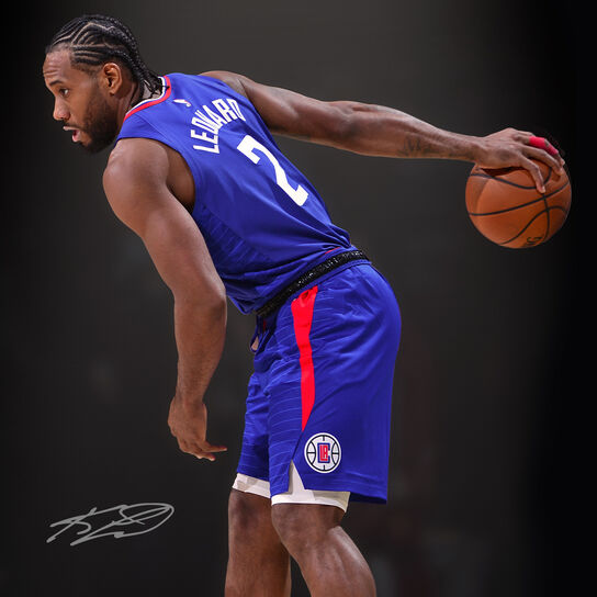 Clippers small forward in his blue uniform palming the ball.