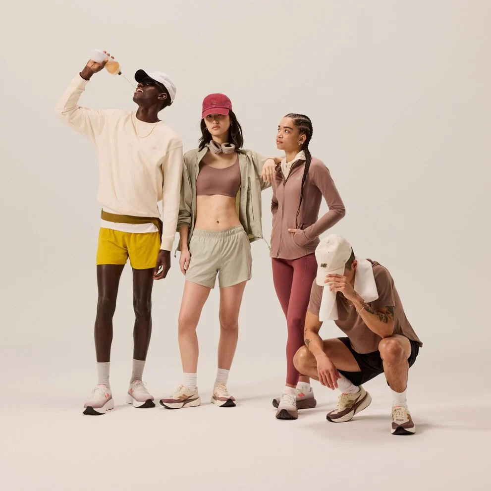 Group of young, adult runners standing next to each other on a beige background. 