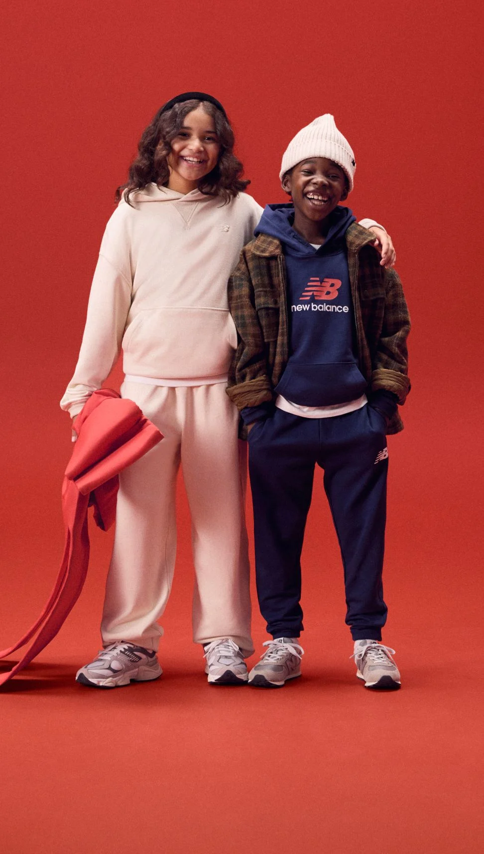 Two kids with arms around each other smiling. 