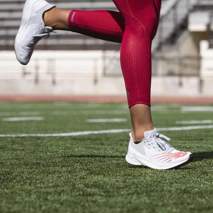Sydney McLaughlin’s legs shown running on field wearing white FuelCell Prism