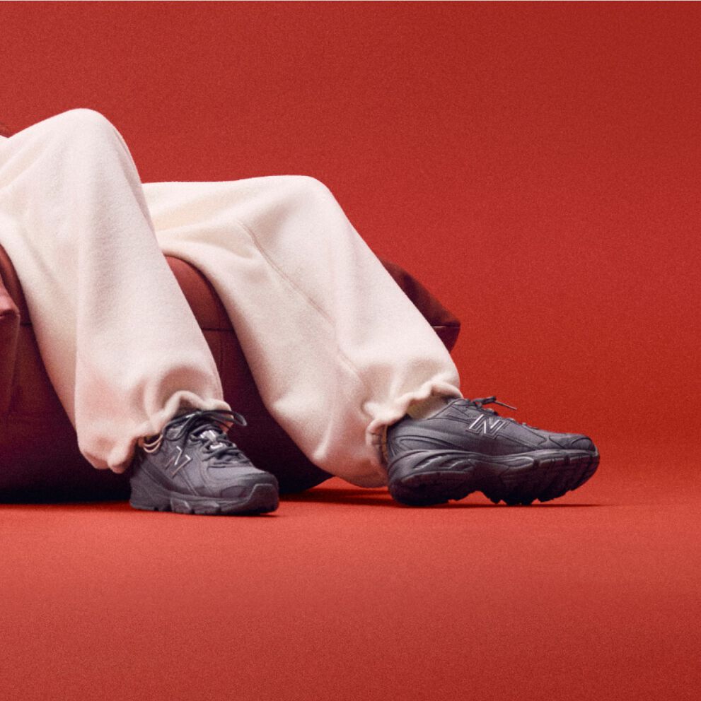 Model sitting on a couch wearing black shoes.