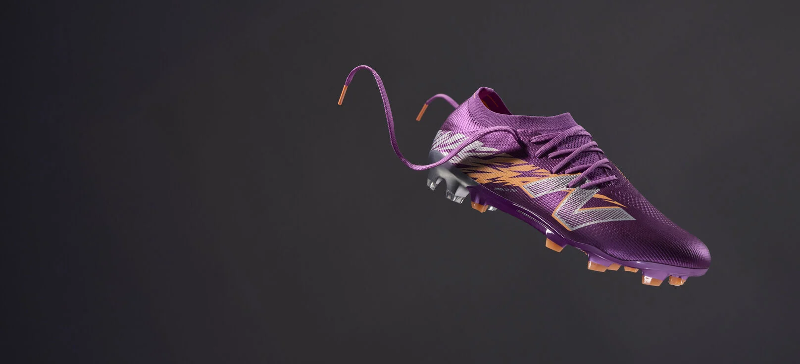 Toutes les bottes de football violettes flottent dans les airs sur un fond gris foncé.