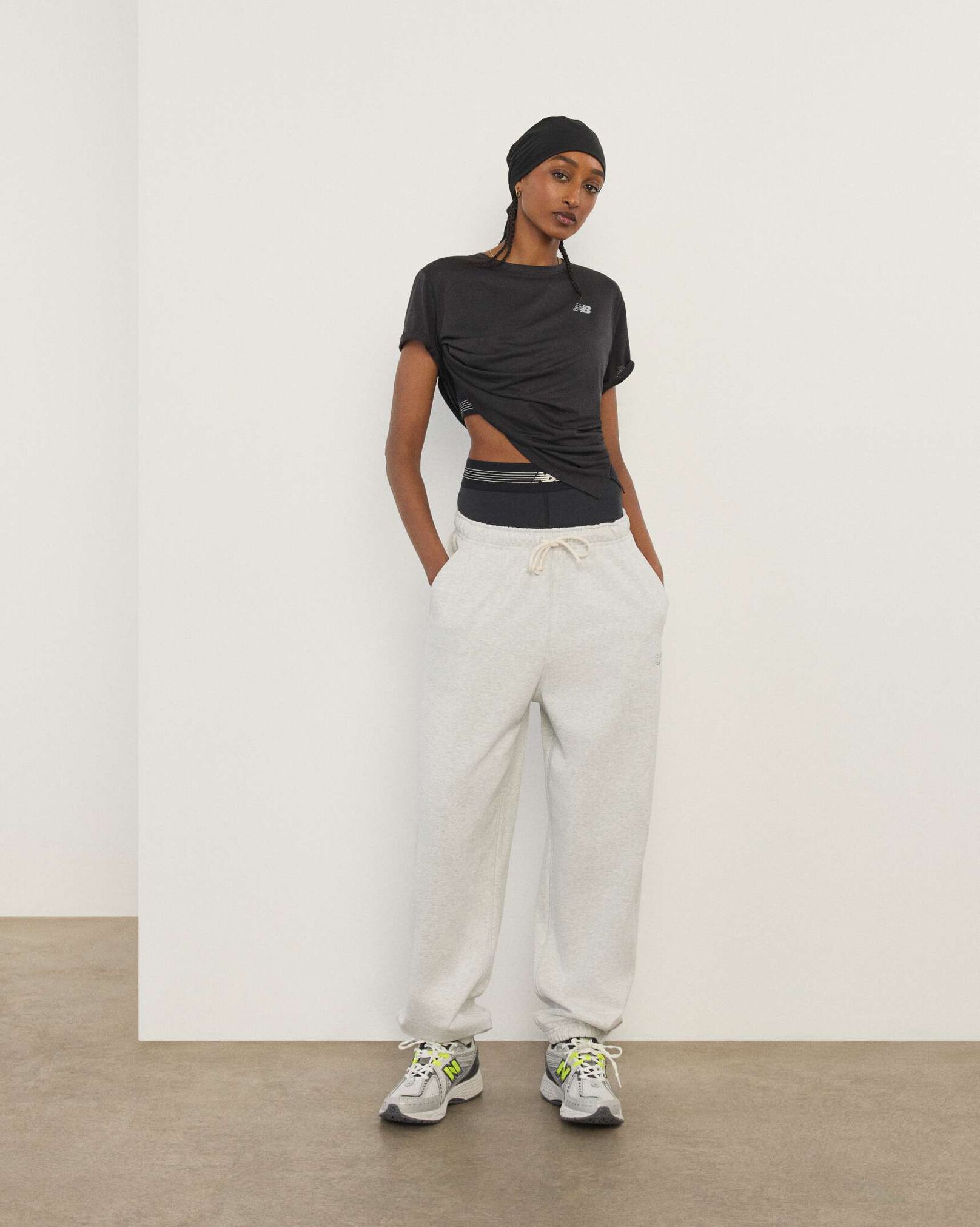 A woman standing in front a white wall.