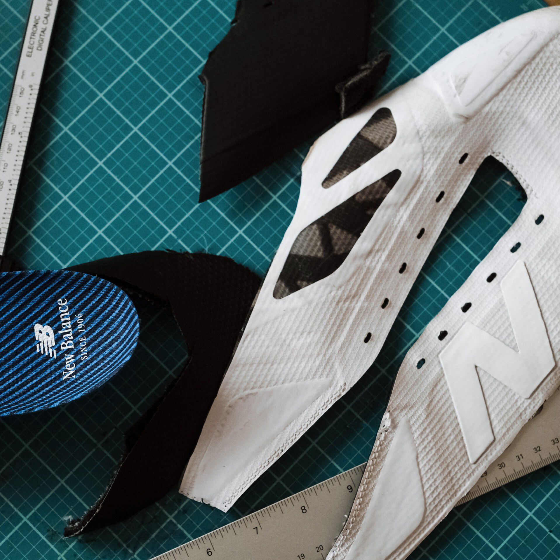 Disassembled shoe sitting on an artist’s green grid.