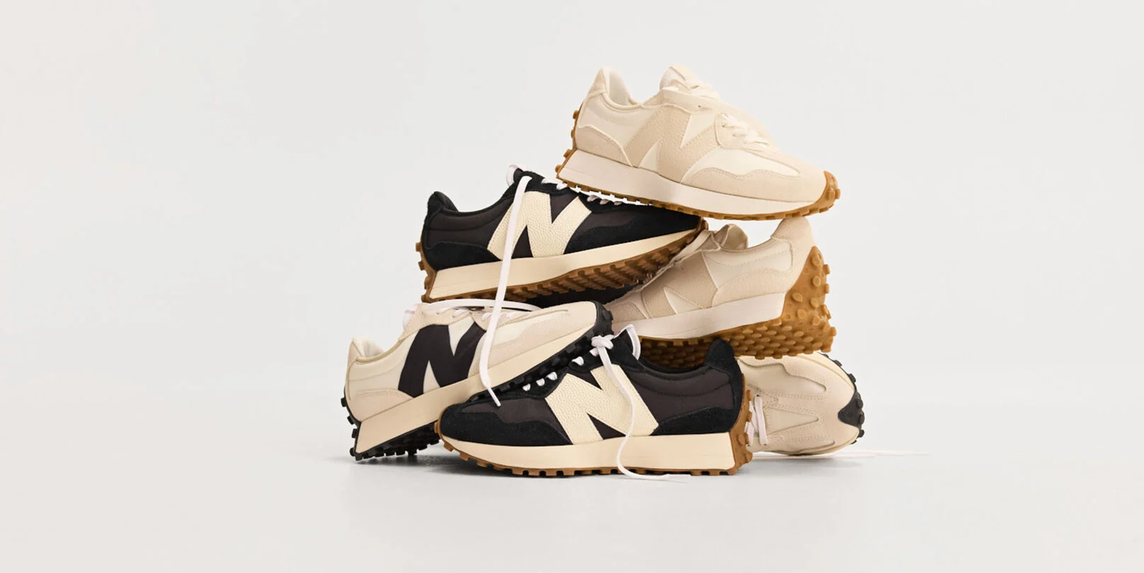Pile of multiple New Balance sneakers on white background. 