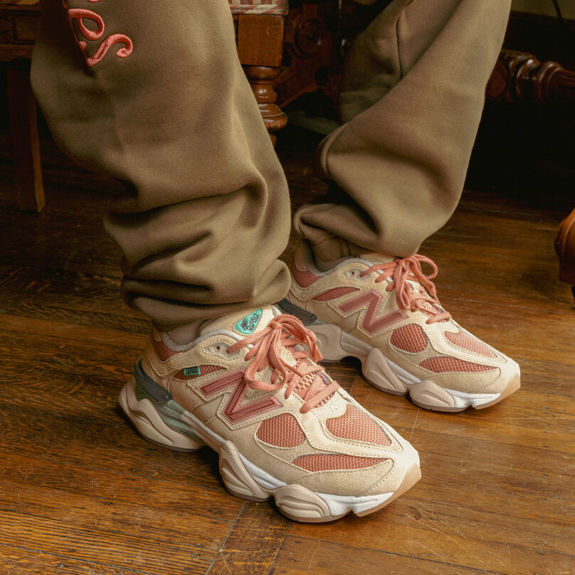 Knee down image of person wearing beige sweatpants and light pink 9060 shoes