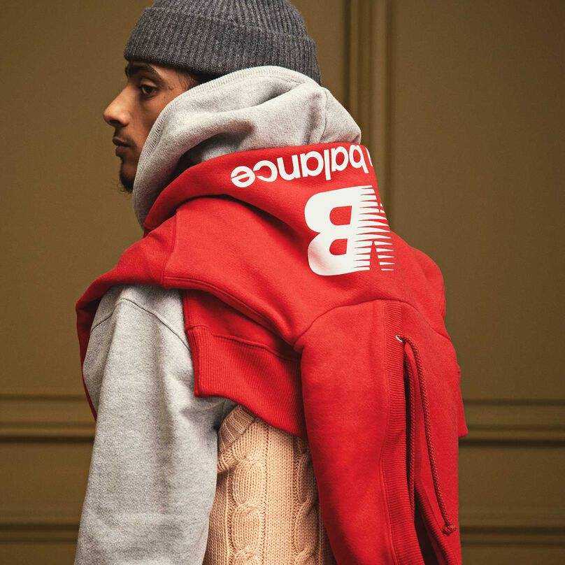 Homme regardant par-dessus son épaule dans un sweat à capuche MADE in USA Heritage entourant ses épaules.