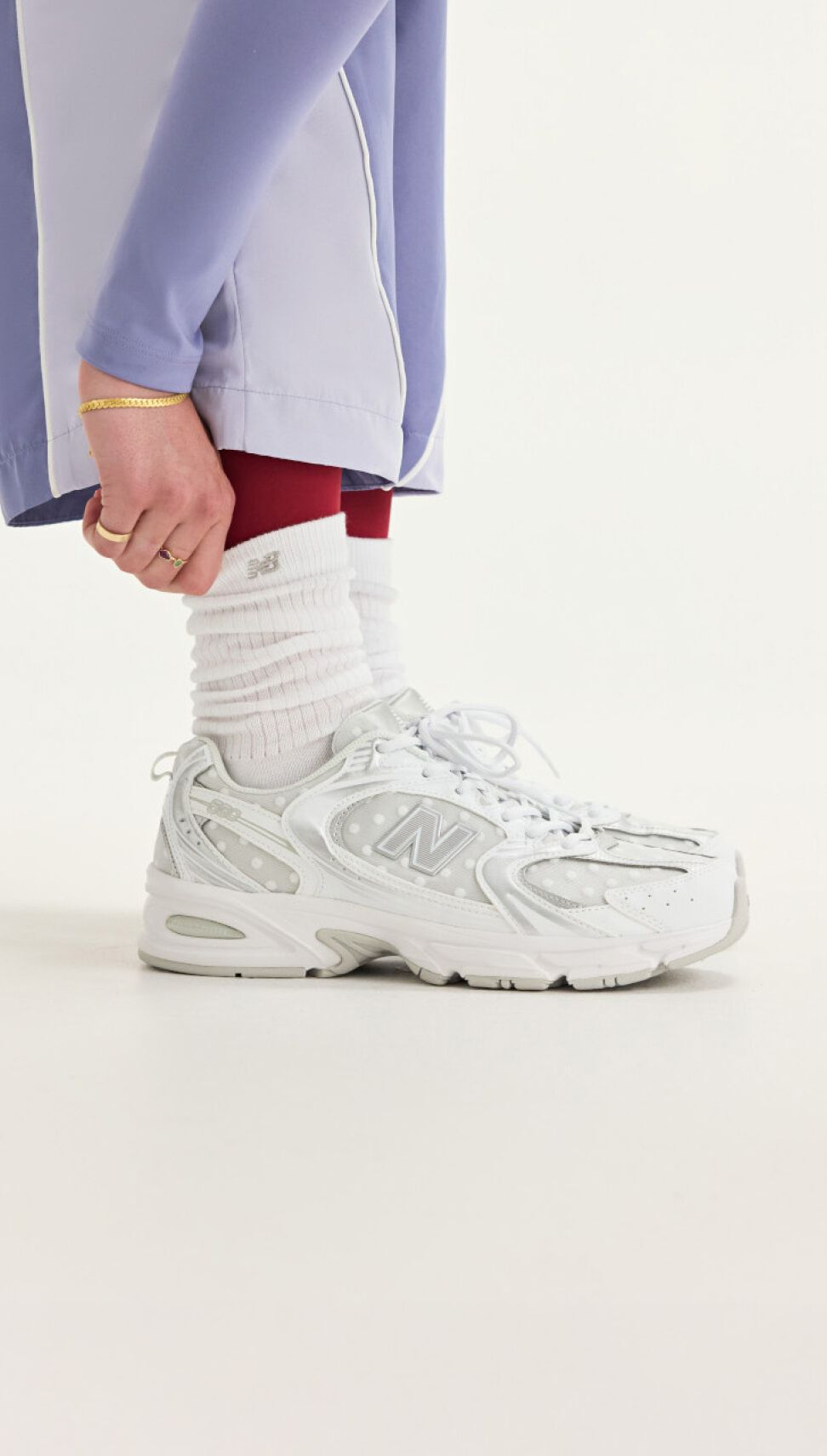 Stack of three New Balance sneakers on white background.