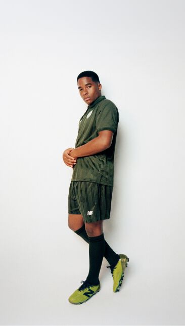 Endrick leaning against a wall wearing a green soccer uniform with his arms together