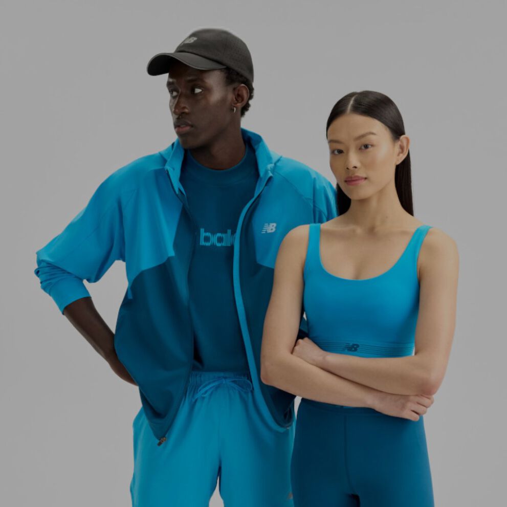 Un homme et une femme portant des v&ecirc;tements New Balance bleus sur un fond blanc.