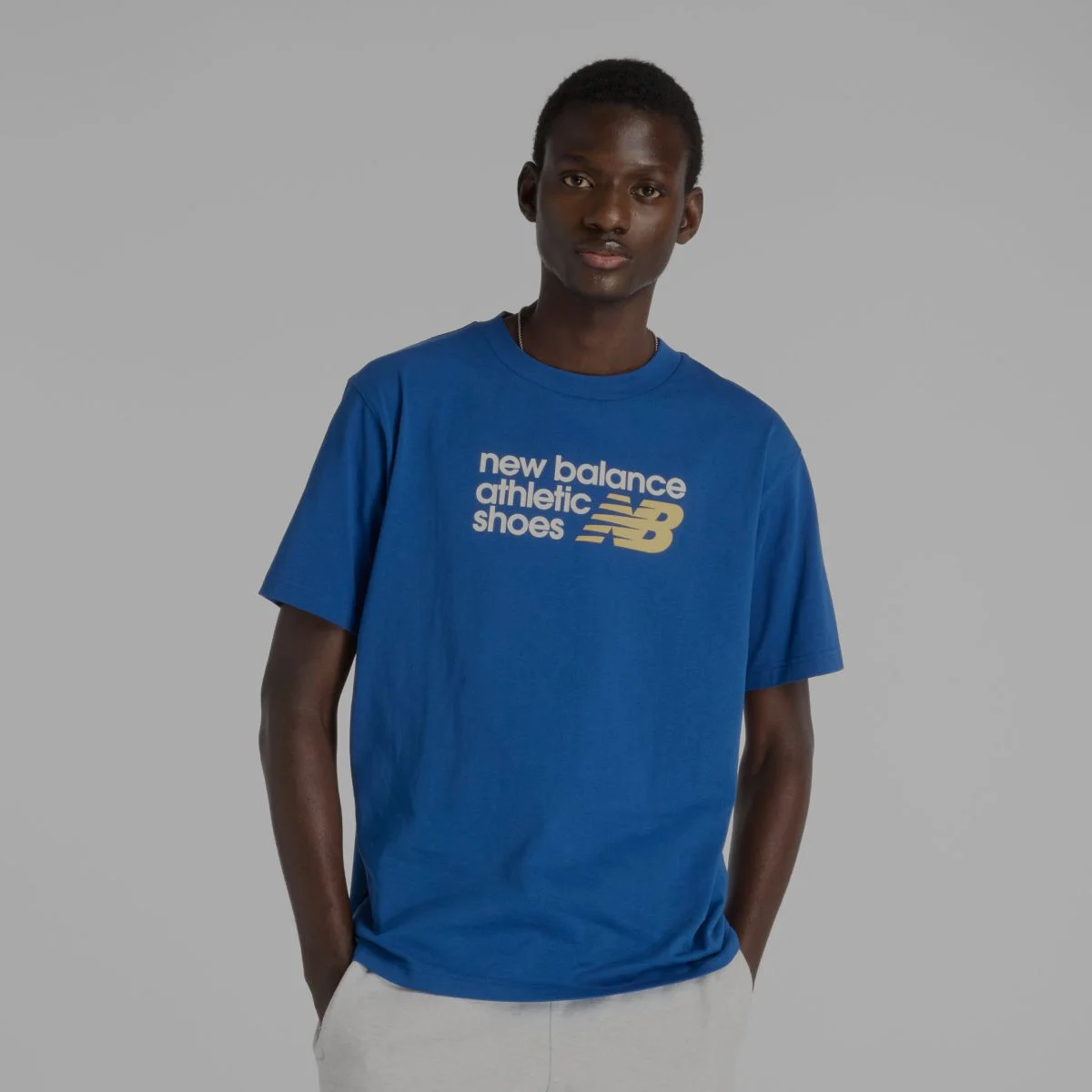 Un homme en tee-shirt graphique bleu de New Balance.