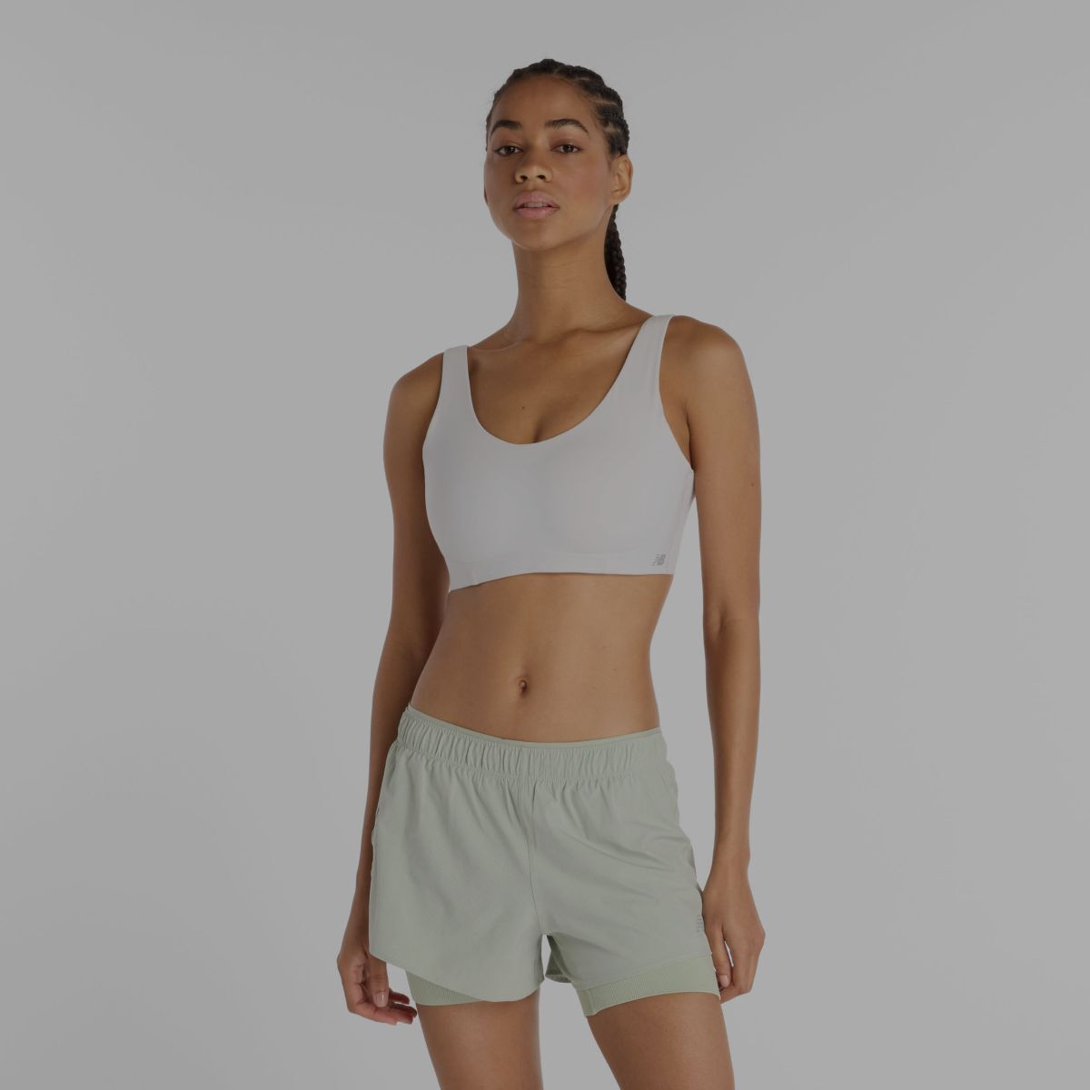 Une femme portant un soutien-gorge de sport blanc New Balance.