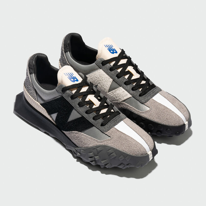 Pair of black and grey XC-72 shoes posed against grey studio background