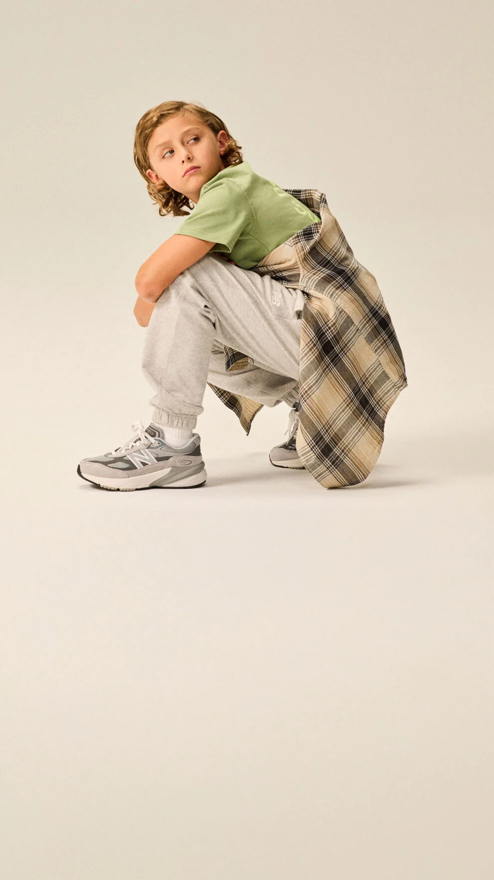 Boy wearing a pair of 990v6&nbsp;shoes.