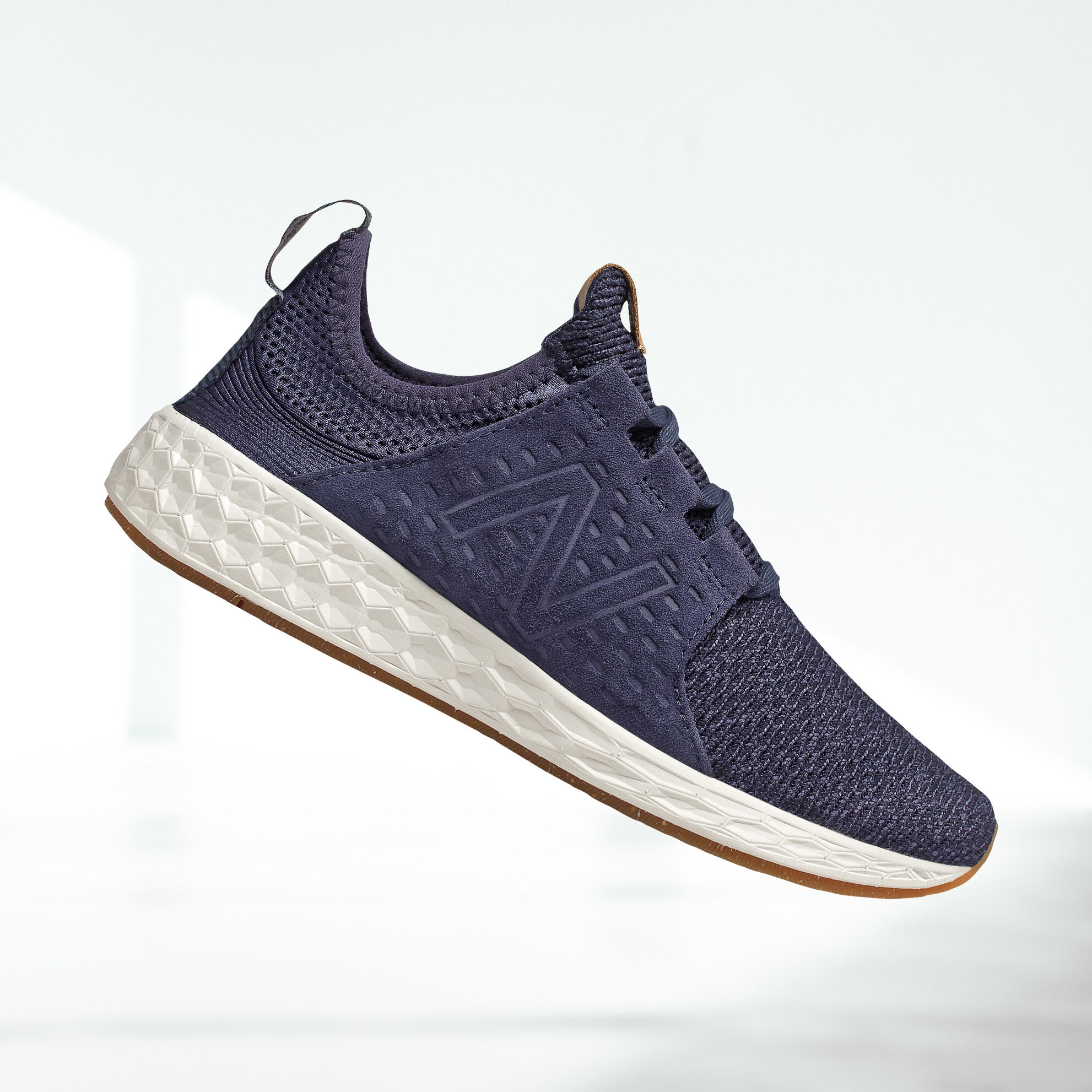 Side view of navy Fresh Foam Cruz v1 floating in midair