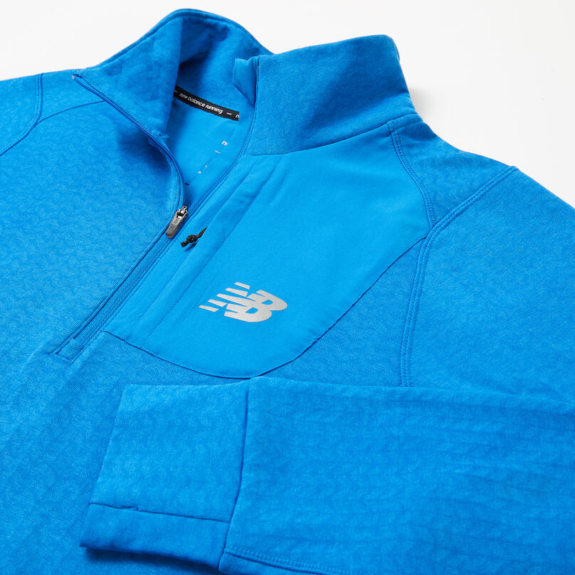 Veste bleue pour homme posée sur un fond gris mettant en évidence le col.