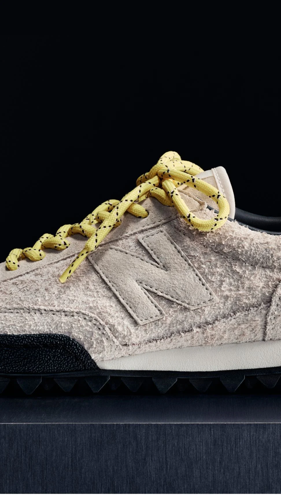 A pink suede Gator Run shoe on a black background.