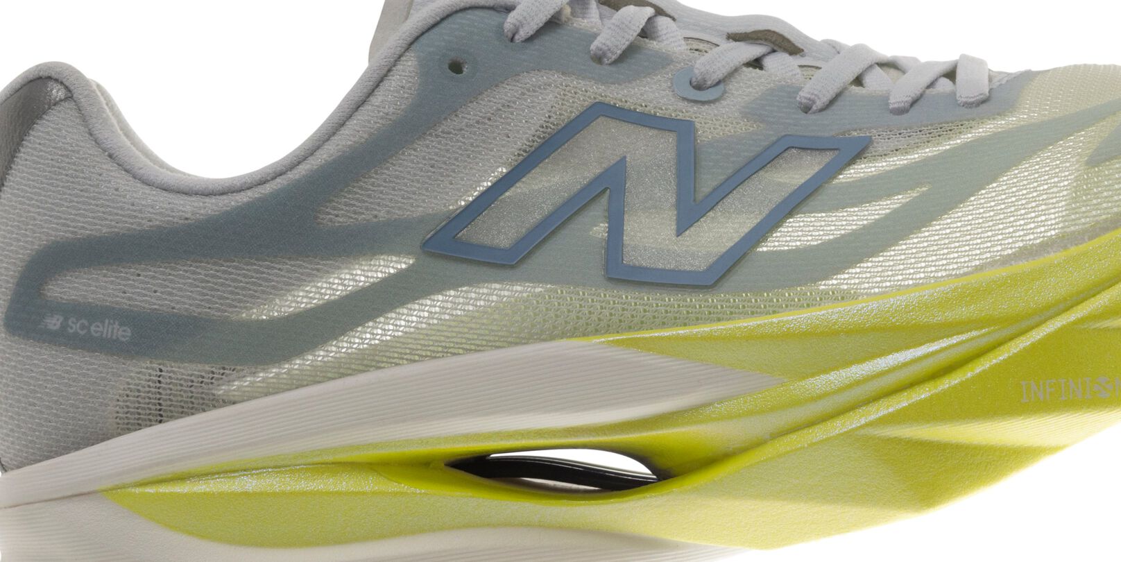 Vue lat&eacute;rale en gros plan d&rsquo;une chaussure de course New&nbsp;Balance pr&eacute;sentant une empeigne en filet gris p&acirc;le, le logo &laquo;&nbsp;N&nbsp;&raquo; bleu, des lacets blancs et une semelle intercalaire sculpt&eacute;e vert lime dot&eacute;e d&rsquo;un syst&egrave;me d&rsquo;amorti apparent &agrave; cavit&eacute; ouverte.&nbsp;