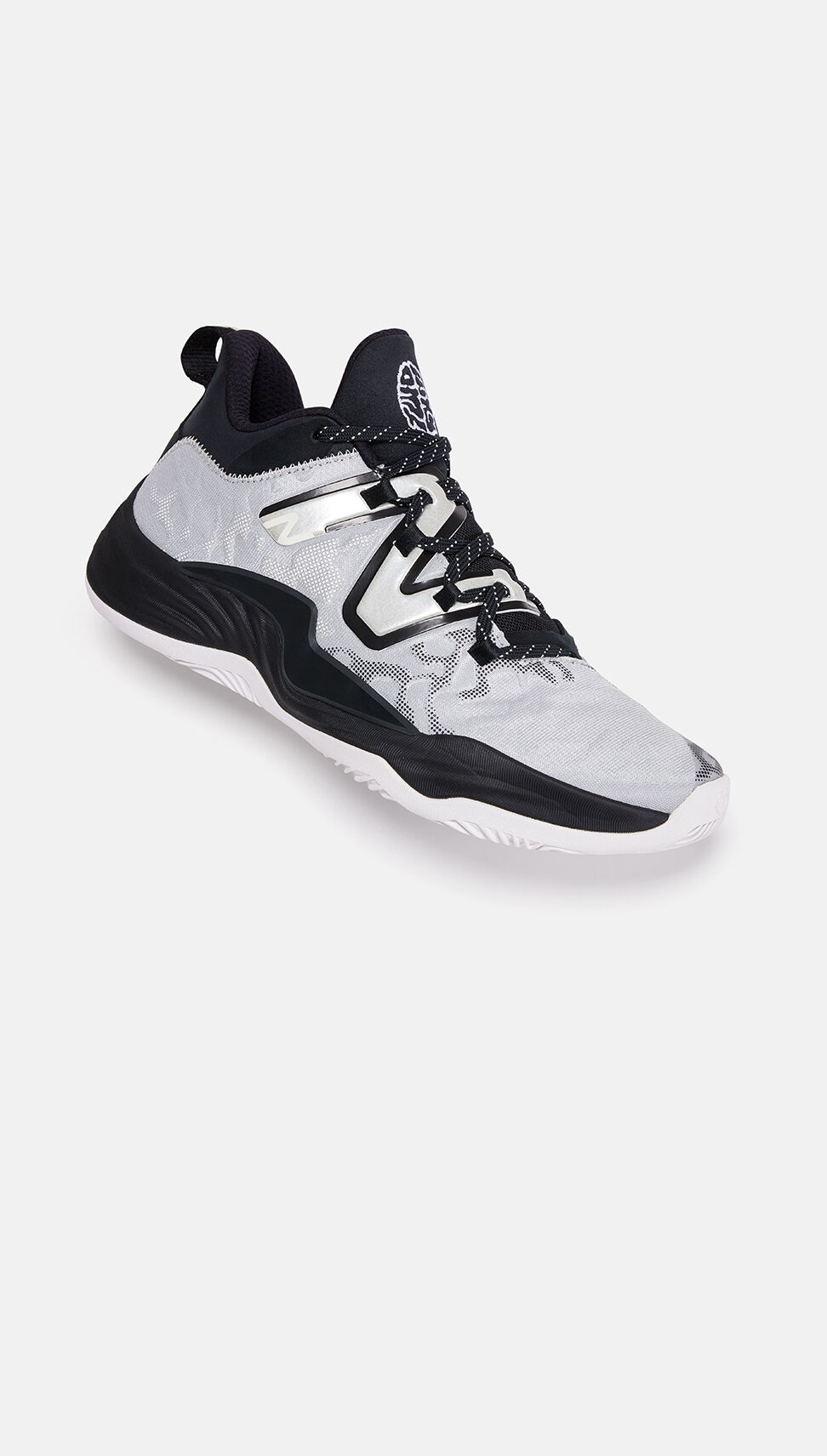 Black and white basketball shoe laying on its side on a grey background.