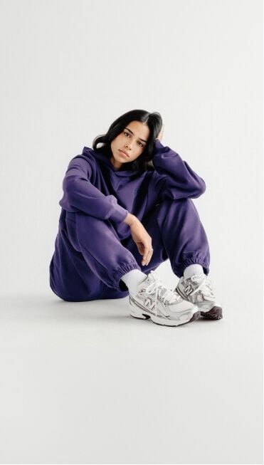 Femme en uniforme violet assise par terre.