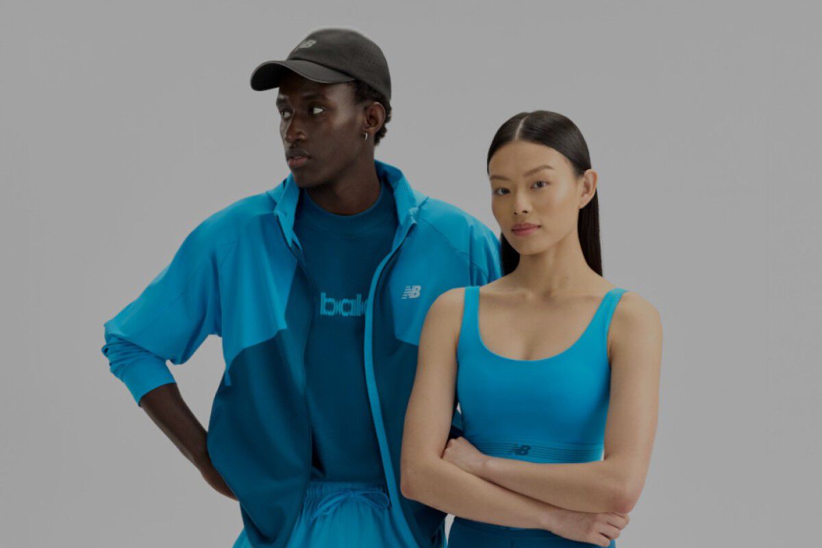 Un homme et une femme portant des v&ecirc;tements New Balance bleus sur un fond blanc.