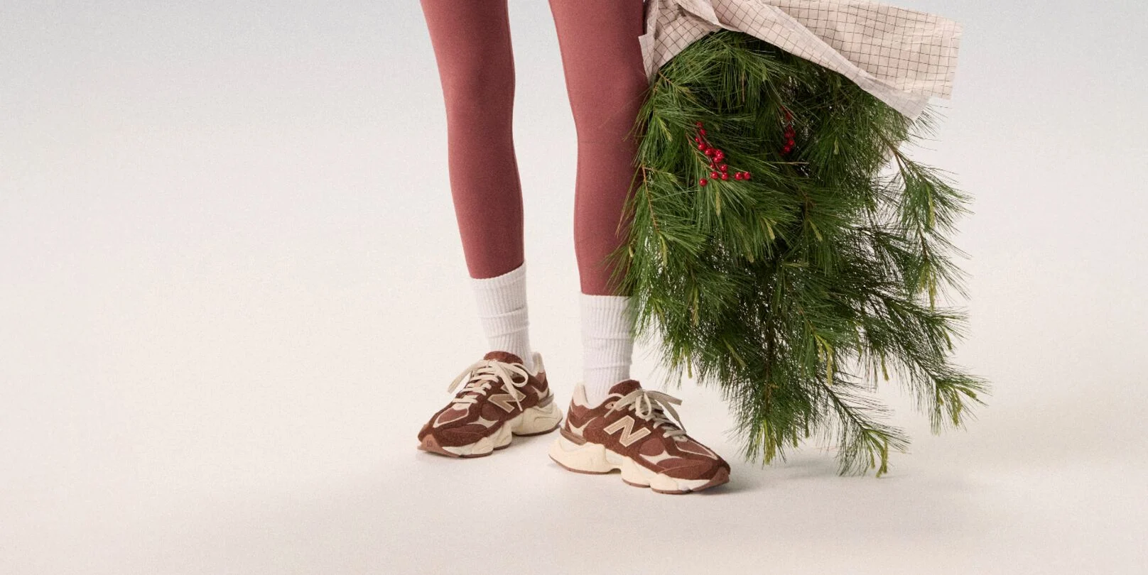 Young woman in maroon tights holding a bag of garland.