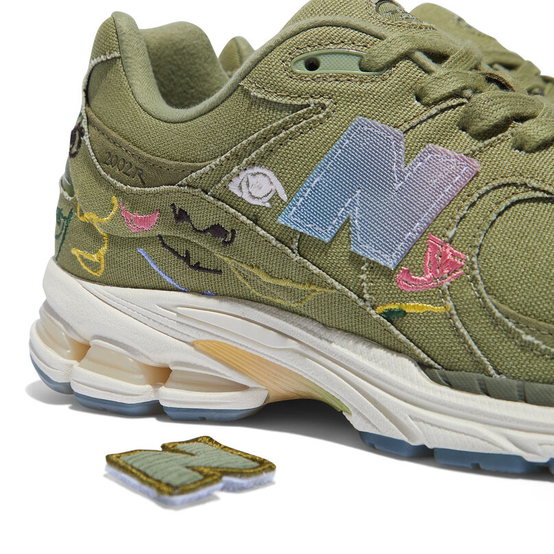 Cropped side profile view of the heel of the olive green 2002R shoe