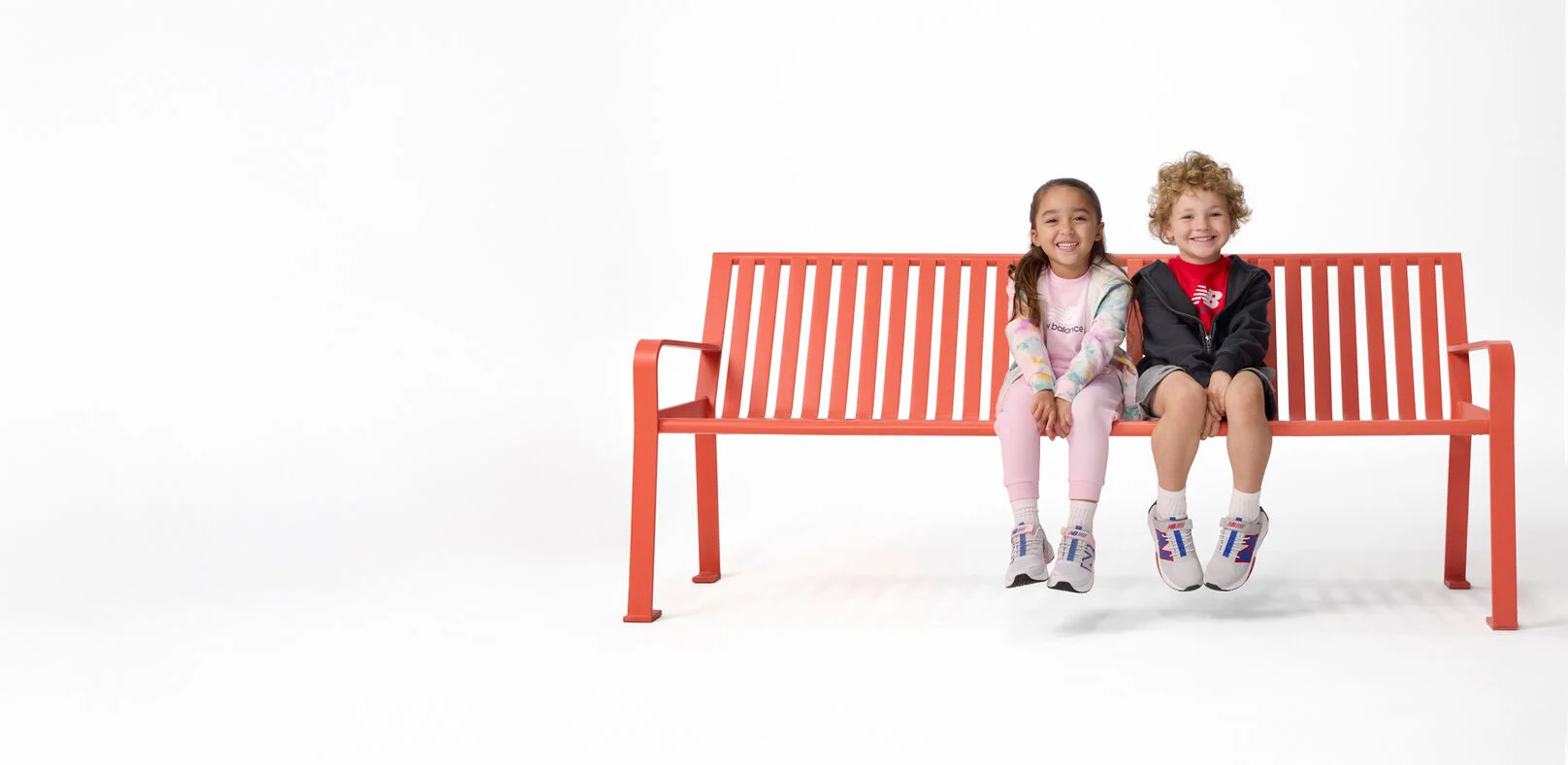 Garçon et fille assis sur un banc rouge 