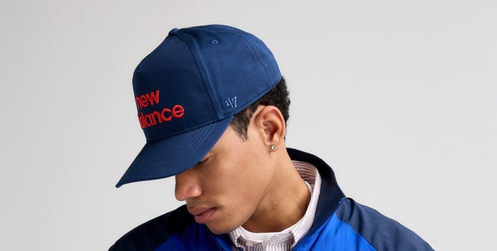 Un gros plan d&rsquo;un homme regardant sur le c&ocirc;t&eacute; tout en portant un chapeau bleu marine de '47.