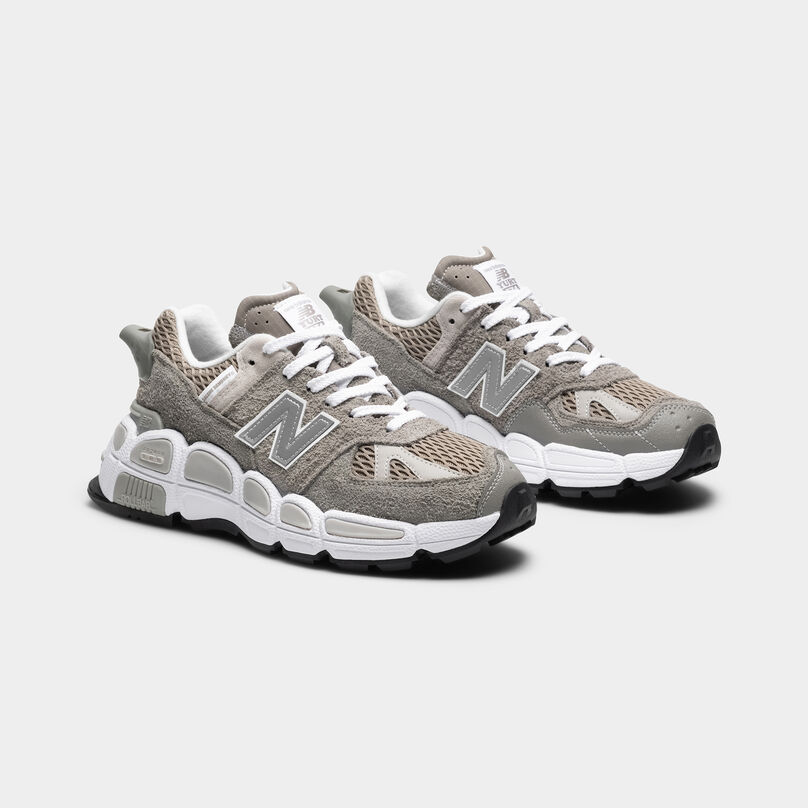 Pair of the grey shoes sitting on a light grey background.