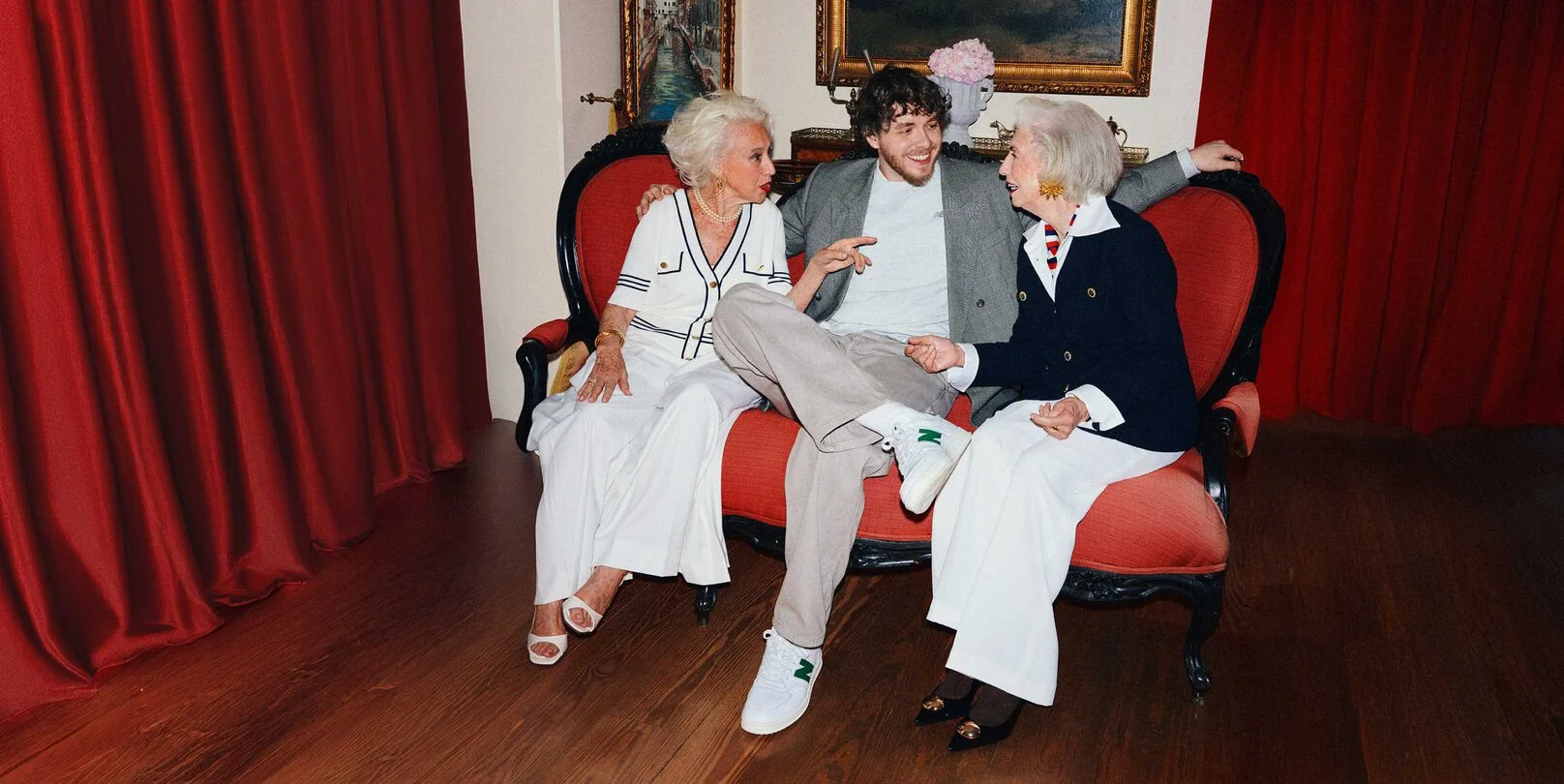 Jack Harlow sitting on a couch and talking to two other people. 