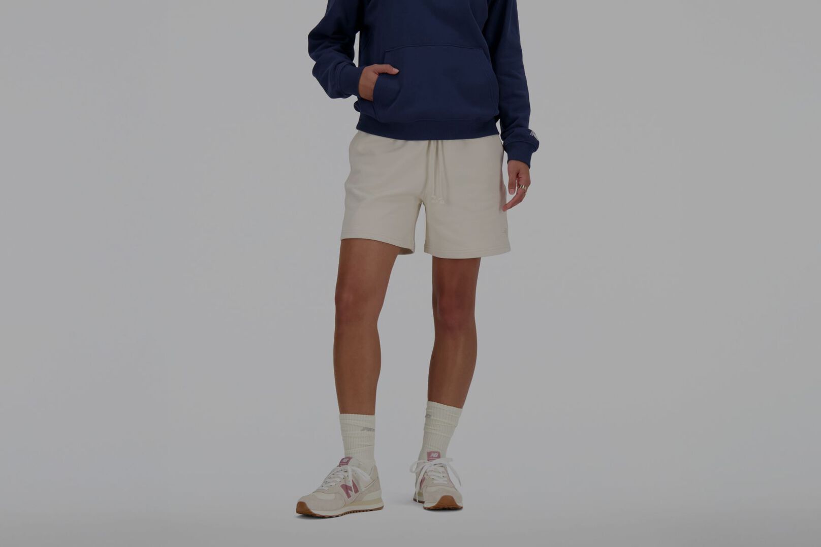 Person wearing white New Balance shorts.
