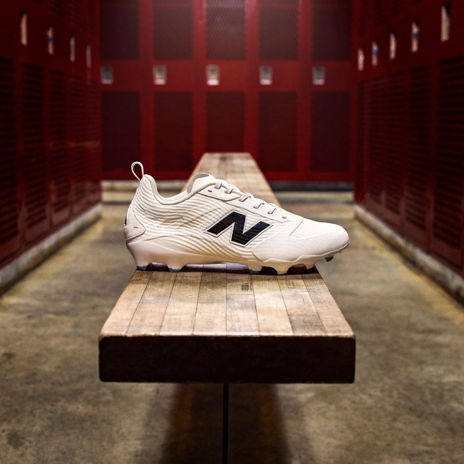 A white Rev iQ football cleat on a bench in a locker room.