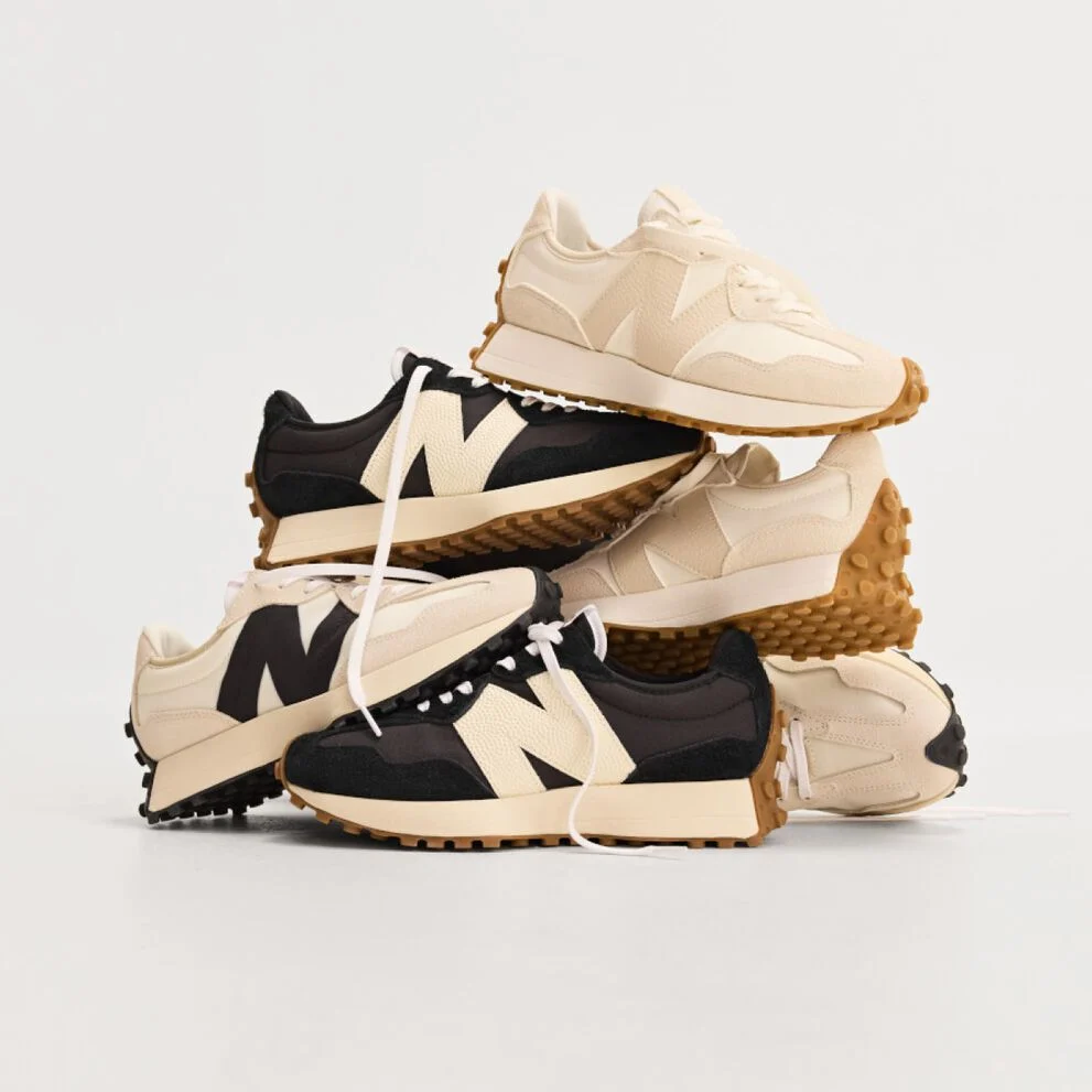 Pile of multiple New Balance sneakers on white background.