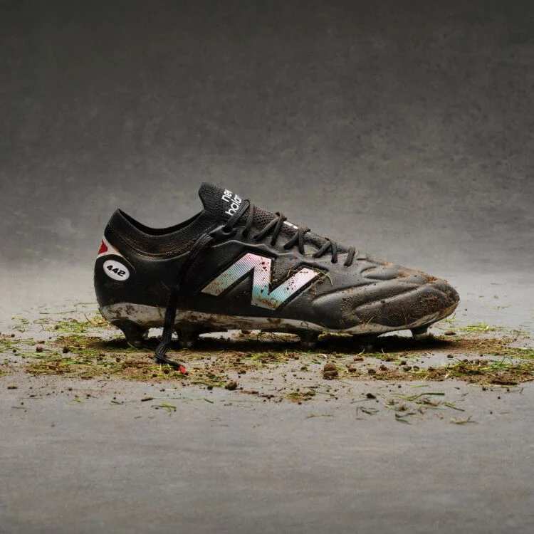 Black and white cleats with dirt on them