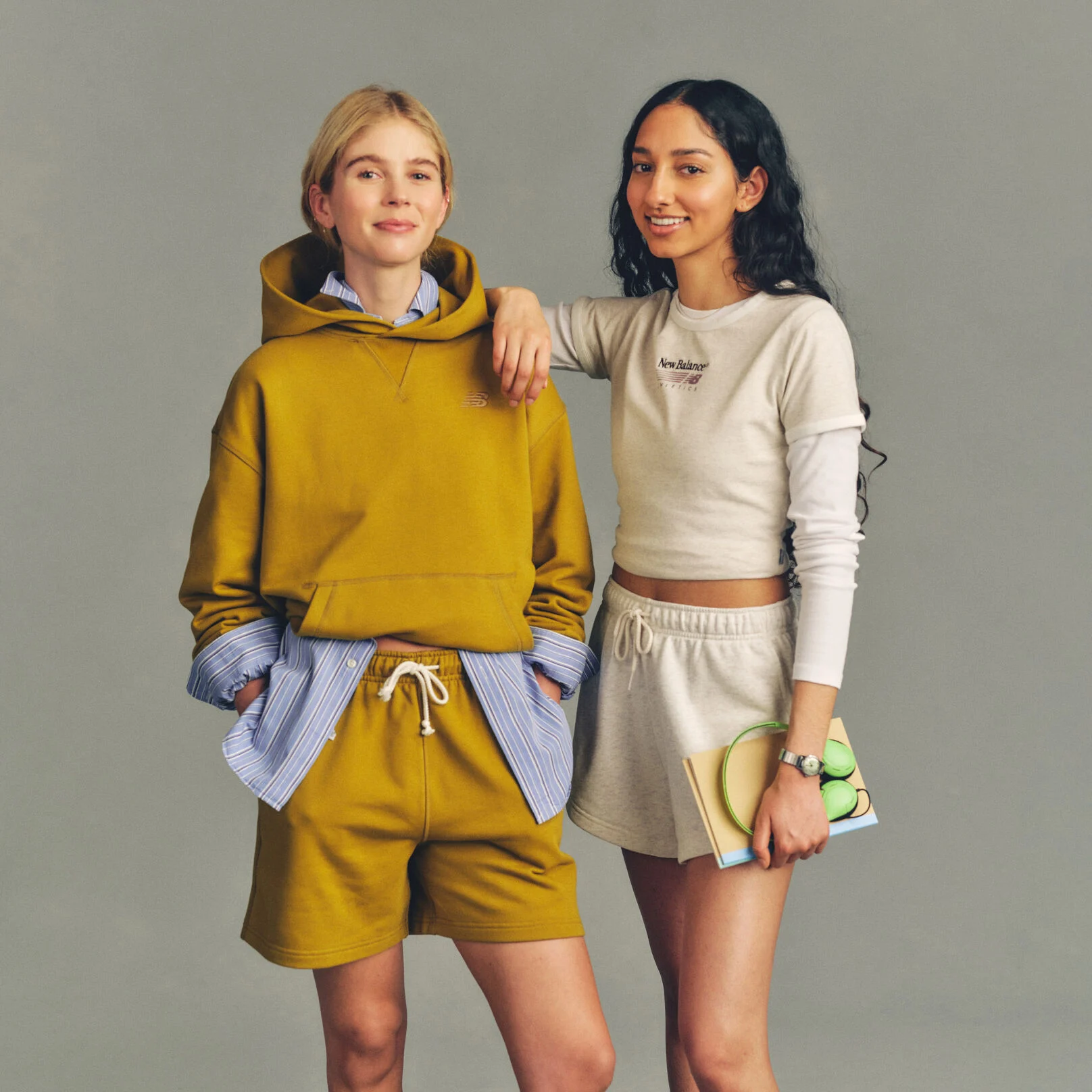 Studio image of two people positioned against a plain light gray background, styled in casual athletic apparel.