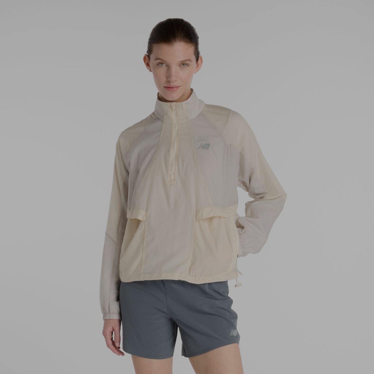 Une femme portant une veste New Balance grise.