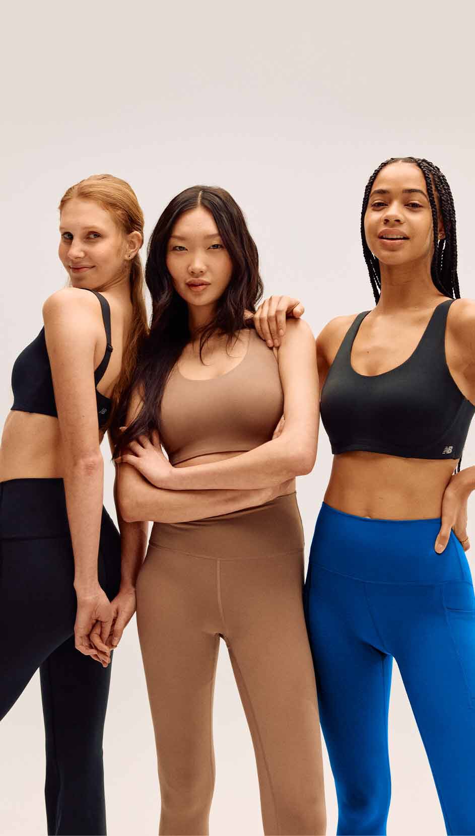 Trois femmes portant des brassières de sport New Balance devant une toile de fond de studio grise.