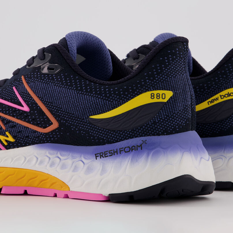 Cropped view of navy Fresh Foam 880v12 shoe, showing the back of the heel, on a grey background