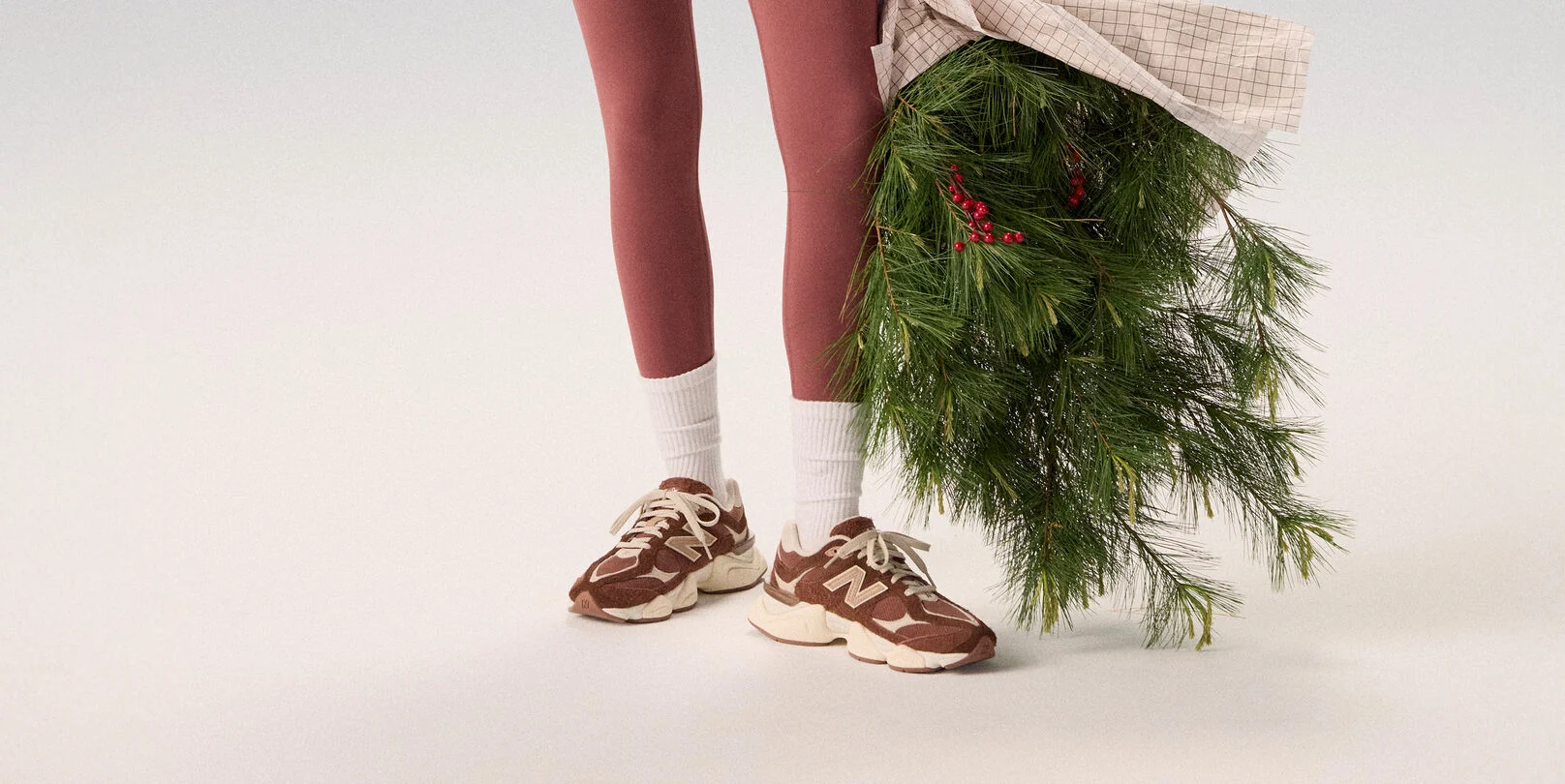 Young woman in maroon tights holding a bag of garland.