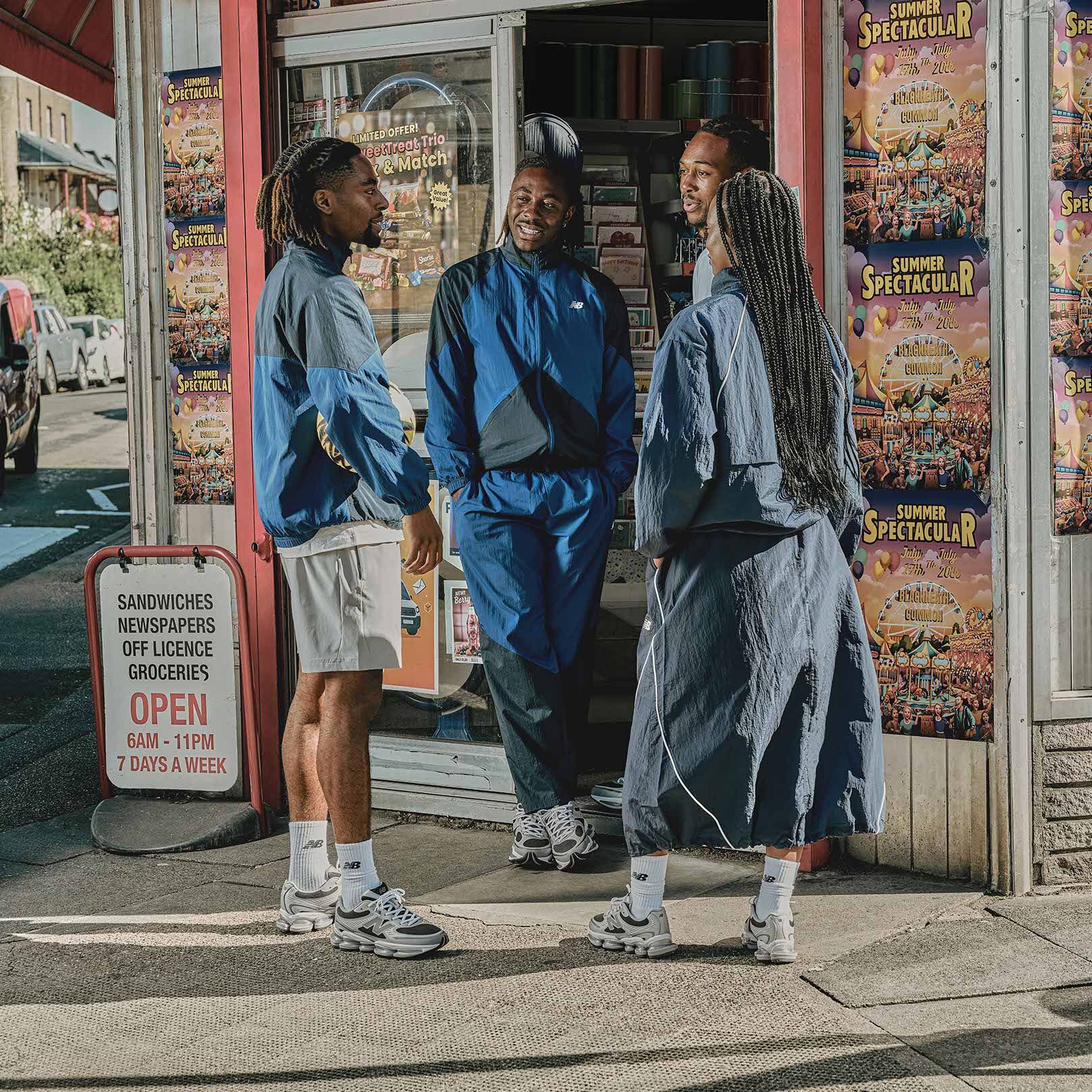Eze debout devant un magasin, les mains dans les poches.