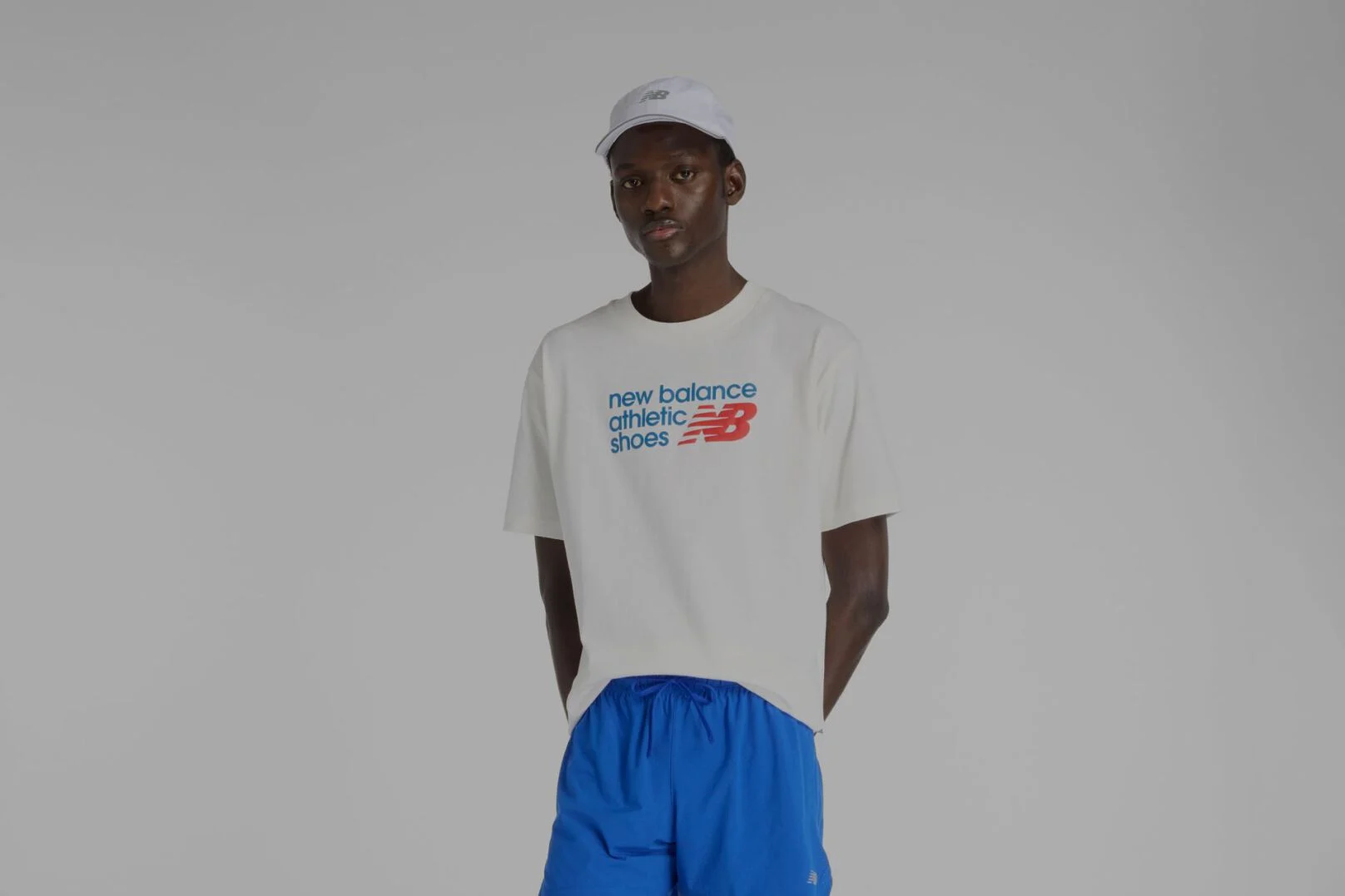 Homme portant une chemise blanche New Balance.