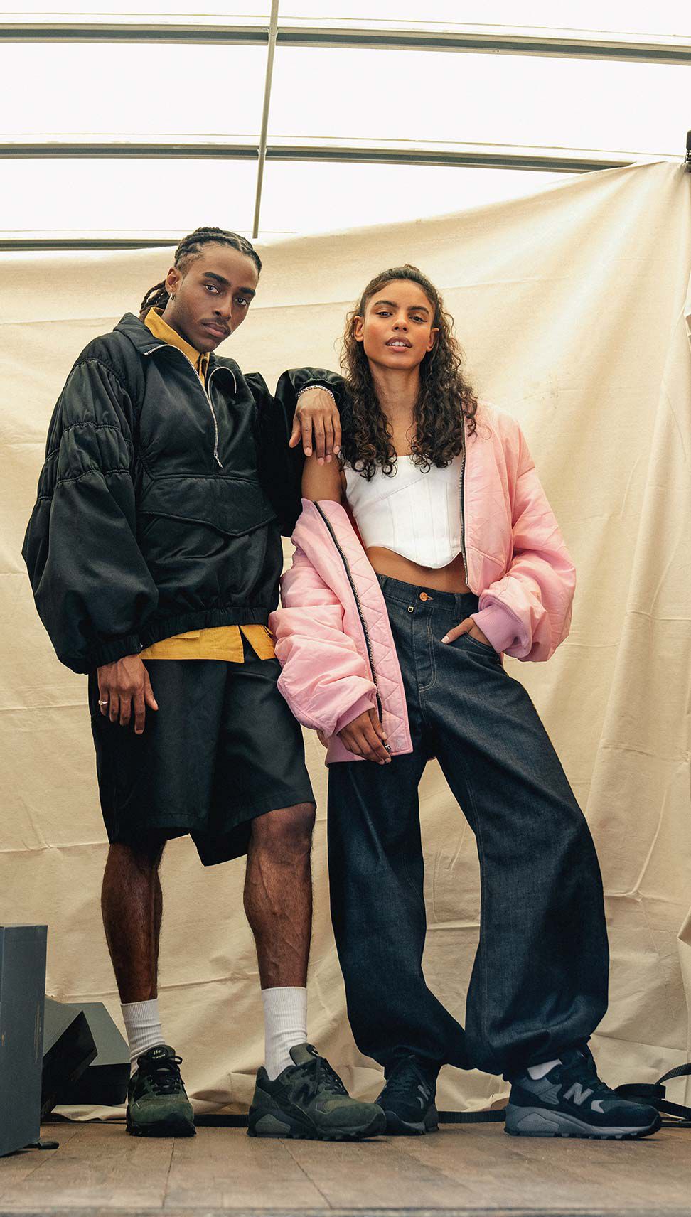 Un homme et une femme debout à l’arrière d’un camion portant les baskets New Balance 580.