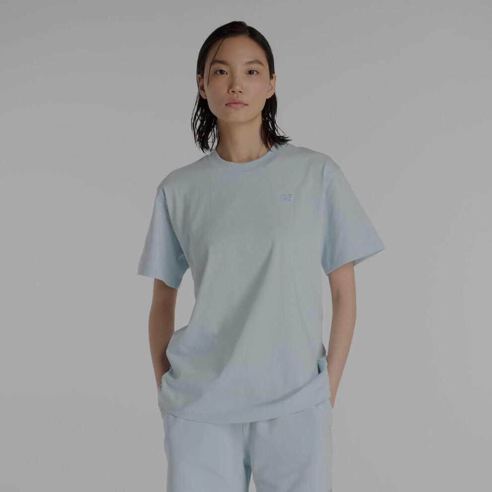 Une femme portant un t-shirt New Balance bleu clair.